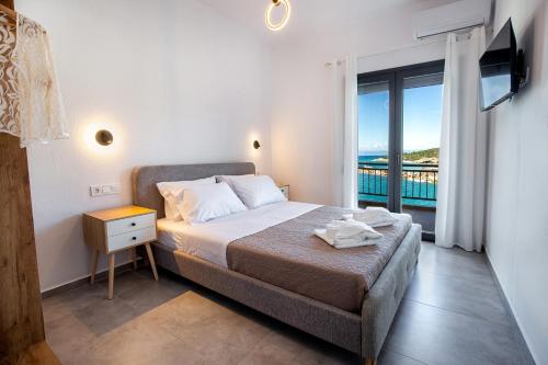 a bedroom with a bed and a window with a view at Sea U - Apartment in Skala Marion