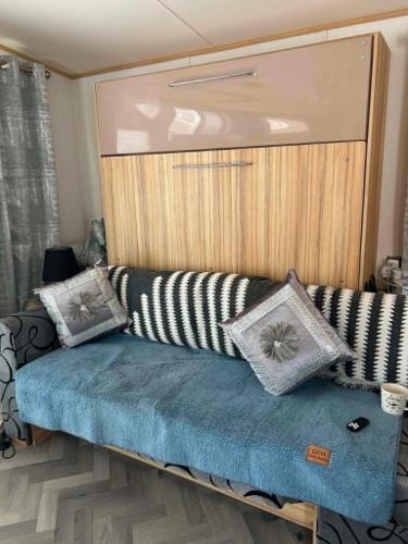 a couch with pillows on it in a room at The Pointon-Bordeaux Caravan Co in Rhyl
