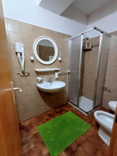 a bathroom with a sink and a shower with a mirror at Casa Vacanze Boario in Boario Terme
