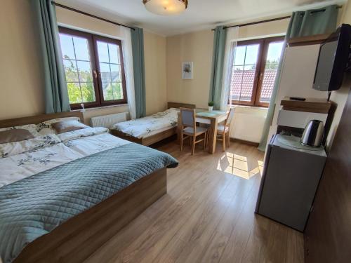 a bedroom with a bed and a table and windows at Willa Hydrograf - rowery i parking bezpłatnie in Ustka