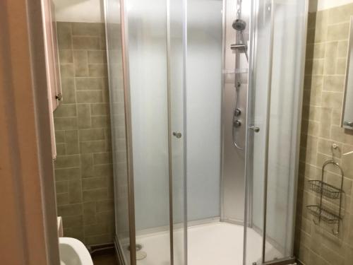 a shower with a glass door in a bathroom at Maison des barrys in Ispagnac