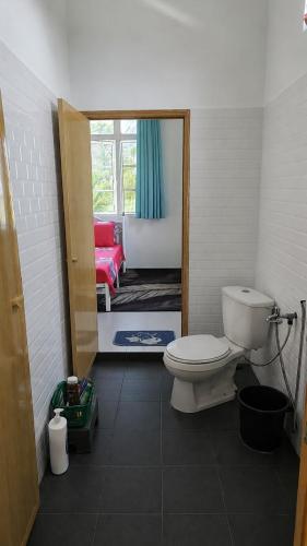 a bathroom with a toilet and a bedroom at Homestay D'Bunohan in Tumpat