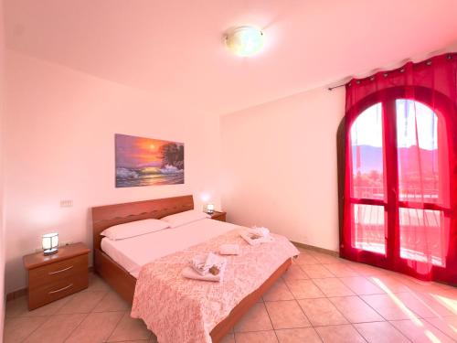a bedroom with a bed and a large window at Viola House in Villasimius
