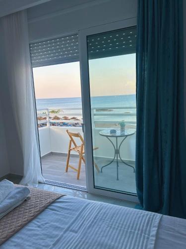 a bedroom with a bed and a view of the ocean at Chrisanthi Apartments in Archangelos