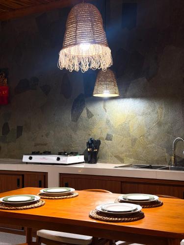 a dining room table with a chandelier above it at Juna Guest House in Uluwatu