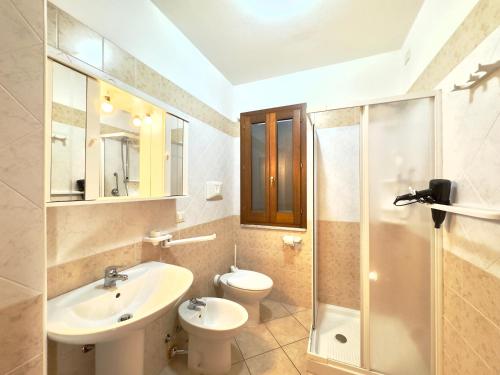 a bathroom with a sink and a toilet and a shower at Viola House in Villasimius