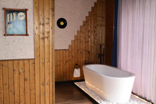 a bath tub in a room with a staircase at Mtaura Cabins in Kazbegi