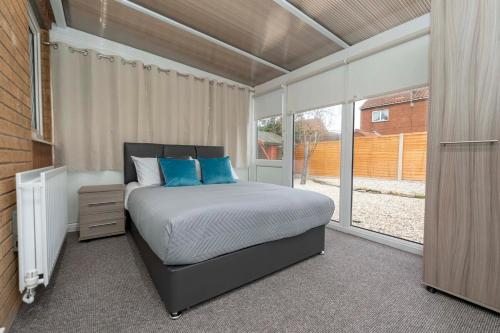 a bedroom with a bed with blue pillows at Park Cottage in Scunthorpe