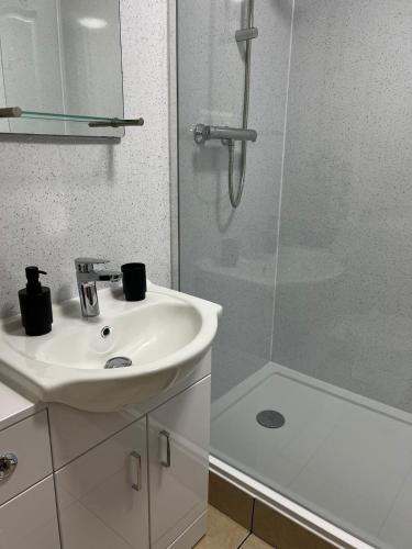 a white bathroom with a sink and a shower at Park Cottage in Scunthorpe