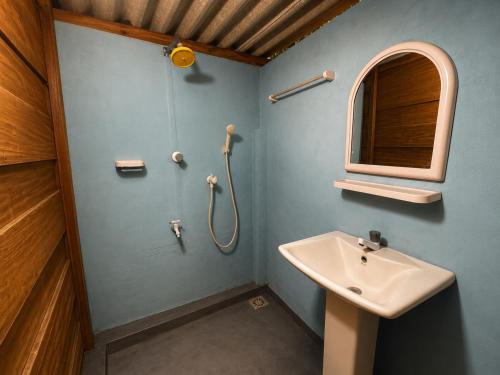 a bathroom with a sink and a shower at once more hostel in Pottuvil