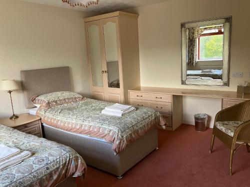 a hotel room with two beds and a mirror at Ardmuir in Turriff
