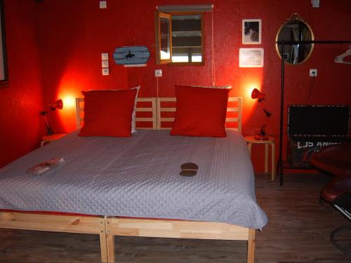 a bedroom with a bed with red walls at Chalet de campagne LAJA only 5 min from autoroute A75 in Léotoing
