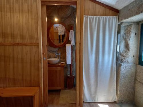 a bathroom with a white shower curtain and a sink at Horizontes Serranos in Tondela
