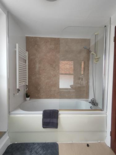 a bathroom with a bath tub with a towel on it at Sand Castle in Weymouth
