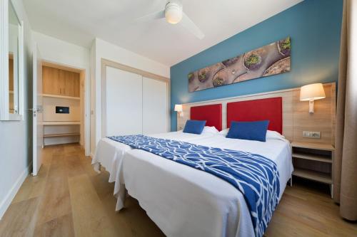 a hotel room with a large bed and blue walls at Hotel Floresta in Puerto del Carmen