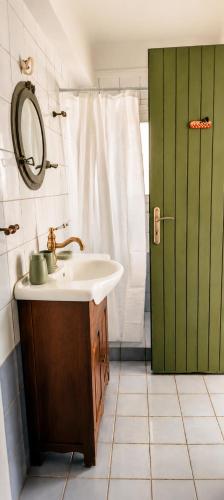 a bathroom with a sink and a green door at Stellinas House 2 in Andros