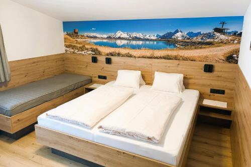 a bedroom with a large bed with a painting on the wall at Pension Glockenstuhl in Finkenberg
