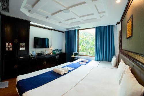 a bedroom with a large bed with blue curtains at Ha Noi Capital Boutique Hotel in Hanoi