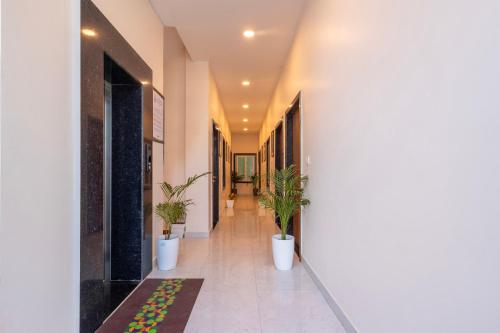 a hallway with potted plants in a building at Treebo Ayodhya Grand in Madnāpur