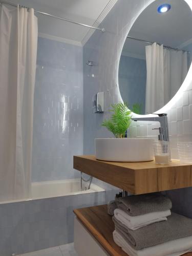 a bathroom with a sink and a mirror and a tub at Apartamento El Ferial in Sarón