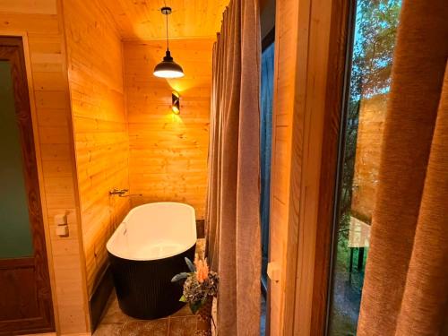 a bathroom with a toilet in a wooden wall at Cottage lima in Kutaisi