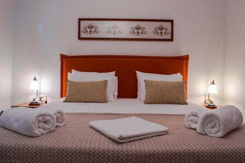 ein Schlafzimmer mit einem Bett, Handtüchern und zwei Lampen in der Unterkunft Feneri Traditional House Apt 1- 20' from Elafonisi beach in Elafonisi