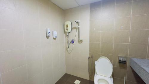 a bathroom with a toilet and a phone on the wall at Desaru Coastline Cribs in Bandar Penawar