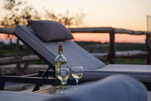 a bottle of wine and two glasses on a table at Stavlos Villa - Private Pool in episkopi-heraklion