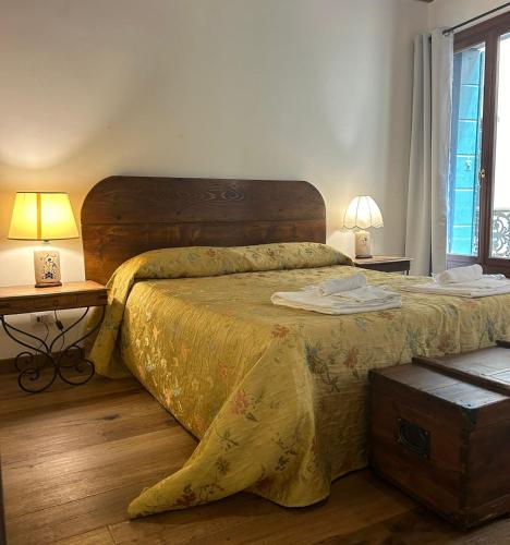 a bedroom with a large bed with a yellow bedspread at Mercerie e Capitello Apartments in Venice