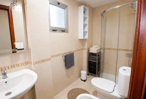 a bathroom with a white toilet and a sink at OPEN SKY VALLEY in Mogán