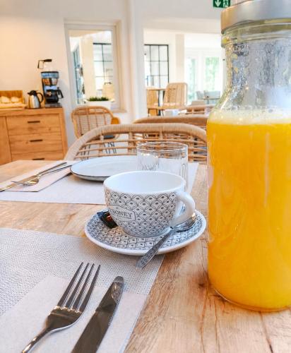 a table with a jar of orange juice and a cup at Lembranza Guest House in Ponte Do Porto