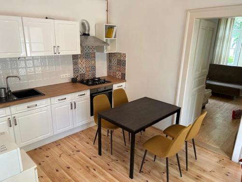 a kitchen with a black table and chairs in a room at Giulia Vendégház in Balatonboglár