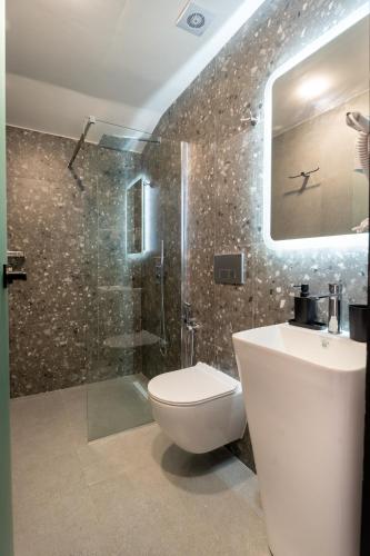 a bathroom with a toilet and a shower and a sink at Villa N&D in Ierissos