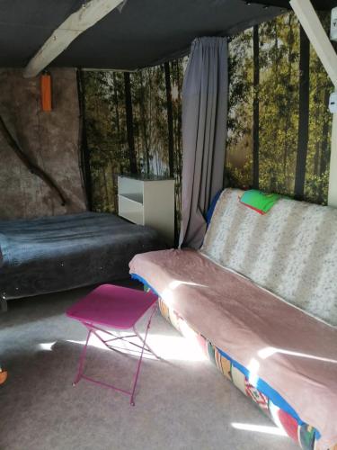 a room with a bed and a chair in it at Cabane insolite au sein d un ranch in Poilhès