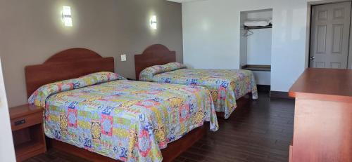 a hotel room with two beds with colorful covers at South Bay Motel in Copiague