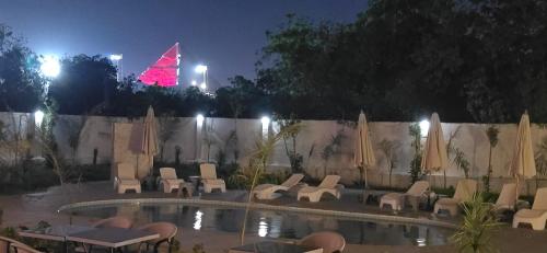 a pool with chairs and a christmas tree in the background at Nakhil Pyramids Resort in Cairo