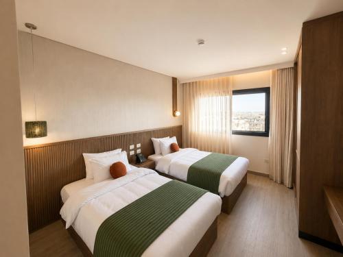 a hotel room with two beds and a window at NOMA New Cairo in New cairo