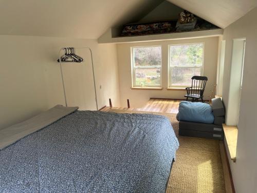 a bedroom with a bed and a chair and windows at Pagosa Chi Camps in Pagosa Springs