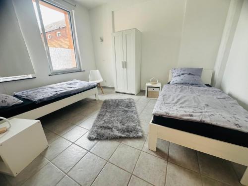 a bedroom with two beds and a window at Loft im Fabrikstil mit 2 eigenen Schlafzimmern mit Wlan und Parkplatz in Groß-Umstadt