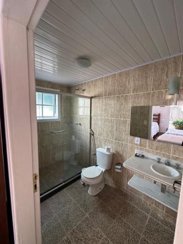 a bathroom with a toilet and a shower and a sink at Flats D'amoras em Conservatória sem café da manhã in Conservatória