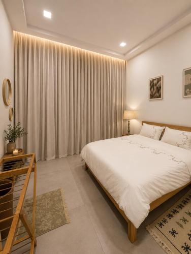 a bedroom with a large white bed and curtains at Blueyes in Tunis