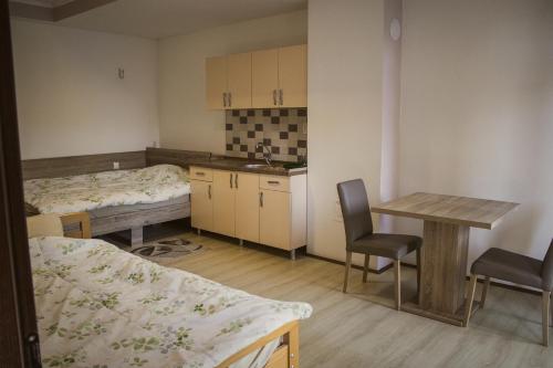 a room with two beds and a table and a kitchen at Stara Charshija - Old Bazaar in Bitola
