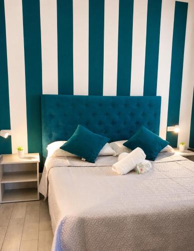 a bedroom with a bed with blue and white stripes at Affitti Brevi SCALA DEI TURCHI in Realmonte