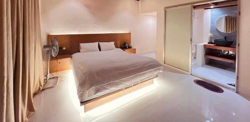 a small bedroom with a bed and a mirror at Ananda Uthaan in Sreemangal