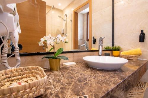 a bathroom with a sink and a mirror at Appartement Au vizir avec Accès au Parc de loisirs in Dar Caïd Layadi
