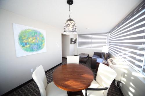 a dining room with a wooden table and white chairs at Wyndham Garden Edmonton Airport in Leduc