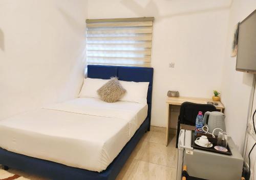 a small bedroom with a bed and a desk at The Basileia Court in Janman