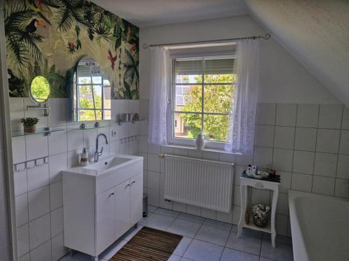 a bathroom with a sink and a tub and a window at Lilly & Fine in Zingst