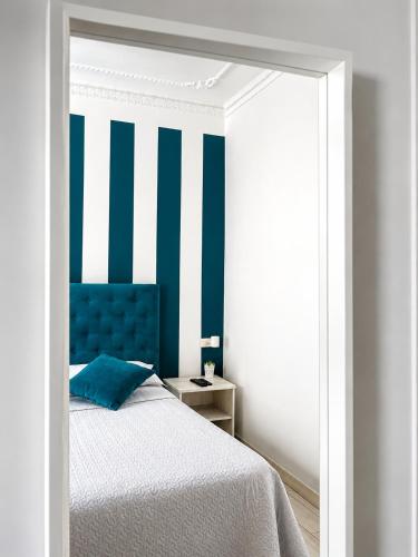 a bedroom with a bed with a blue head board at Affitti Brevi SCALA DEI TURCHI in Realmonte