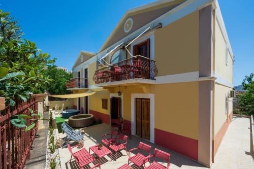 a patio with red chairs and a building at Pinotsi Rooms Village Symi in Symi